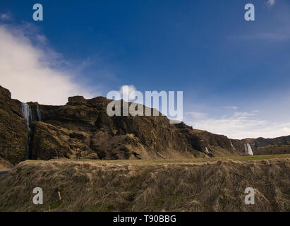 Una piccola collina con numerose cascate in background, lungo la catena montuosa Foto Stock