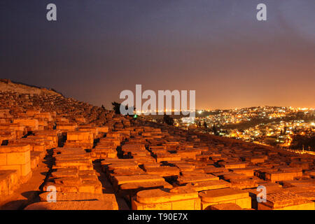 Gerusalemme, Israele - marzo 03rd, 2015: vista notturna sul cimitero ebraico sul Monte degli Ulivi, le luci della città di Gerusalemme in background Foto Stock