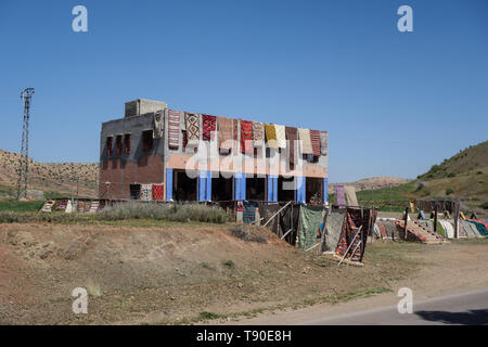 Colorati tappeti tessuti appesi su una facciata della casa in un villaggio Berbero in Atlas Mountains, vicino a Marrakech, Marocco Foto Stock