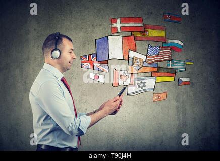 Business man in cuffie utilizzando il telefono cellulare app imparare diverse lingue Foto Stock