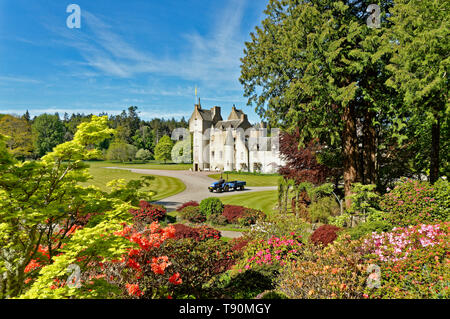 Il castello di BALLINDALLOCH BANFFSHIRE SCOTLAND I giardini in primavera con coloratissime azalee e giardinieri il trattore e il rimorchio Foto Stock