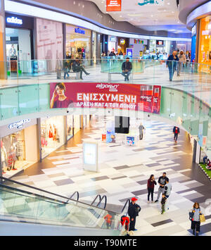 PAHOS, Cipro - 14 febbraio 2019: la gente in centro shopping, interni dal design moderno di Kings Avenue Mall con escalator tra piani Foto Stock
