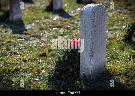 Una corona posta sulla pietra tombale smerigliato in Virginia cimitero nazionale. Foto Stock