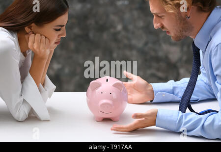 Giovani quarreling giovane con salvadanaio a tavola Foto Stock