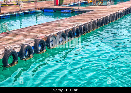 Questa unica foto mostra la partenza pier con la vecchia auto pneumatici ricoperta da alghe marine. La foto è stata scattata in aeroporto in maschio Foto Stock