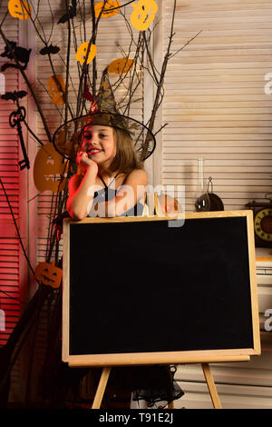 Piccola Ragazza di Halloween a scuola. Venire a scuola per Halloween. Piccola Ragazza strega in hat. Libera scopa con corsi di volo, spazio di copia Foto Stock