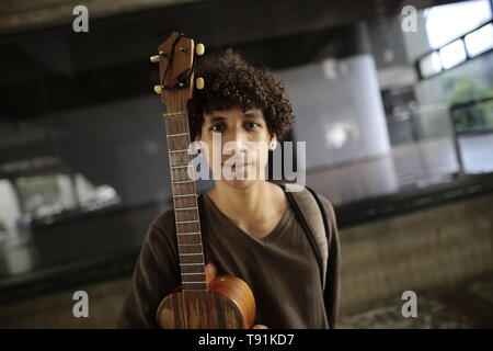 13 maggio 2019, Venezuela, Caracas: Oliver Figueroa cammina con la sua chitarra venezuelano attraverso una strada della capitale venezuelana. Il Venezuela è stato in una profonda crisi per anni. In un indice, il paese si è classificato di 188 su 190 paesi nel 2018. Che cosa si intende per Oliver pensare? 'L'iperinflazione è veramente male proprio ora. Mi suona la chitarra nella metropolitana. Ecco come mi fare soldi. Ma le persone non hanno molto denaro con loro", dice l'22-anno-vecchio. Oliver ha già pensato di emigrare. "Ma sto studiando arte adesso. E io amo il mio paese. Anche se ci troviamo in una situazione difficile, mi piace essere qui", afferma th Foto Stock