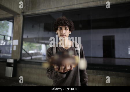 13 maggio 2019, Venezuela, Caracas: Oliver Figueroa cammina con la sua chitarra venezuelano attraverso una strada della capitale venezuelana. Il Venezuela è stato in una profonda crisi per anni. In un indice, il paese si è classificato di 188 su 190 paesi nel 2018. Che cosa si intende per Oliver pensare? 'L'iperinflazione è veramente male proprio ora. Mi suona la chitarra nella metropolitana. Ecco come mi fare soldi. Ma le persone non hanno molto denaro con loro", dice l'22-anno-vecchio. Oliver ha già pensato di emigrare. "Ma sto studiando arte adesso. E io amo il mio paese. Anche se ci troviamo in una situazione difficile, mi piace essere qui", afferma th Foto Stock