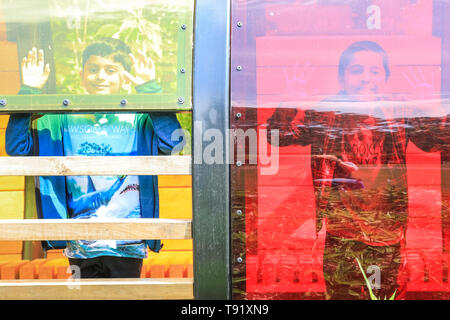 Kew Gardens, Londra, Regno Unito, 16 maggio 2019. Yahya (a destra) e il suo amico divertirsi facendo facce in pannelli colorati del nuovo tunnel di luce. Un nuovo giardino dei bambini è impostata per aprirsi a Londra il famoso Kew Gardens. Il giardino è progettato attorno agli elementi che le piante hanno bisogno di crescere: terra, aria, il sole e l'acqua. Esso copre la dimensione di 40 campi da tennis, con 18.000 piante e 100 alberi maturi, ed è impostato per essere un paradiso per i giovani di esplorare e giocare..NOTA: Autorizzazione concessa. Credito: Imageplotter/Alamy Live News Foto Stock