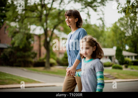 Madre e figlia camminando mano nella mano. Foto Stock