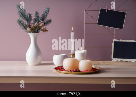 Bella candele accese con decorazioni su un tavolo di legno Foto Stock
