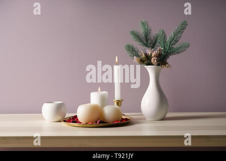 Bella candele accese con abete rami sul tavolo di legno Foto Stock