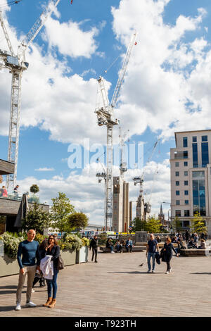 Gli acquirenti e i turisti presso il recentemente aperto del carbone scende cantiere, King's Cross, Londra, Regno Unito, 2019, la riqualificazione continua in background Foto Stock