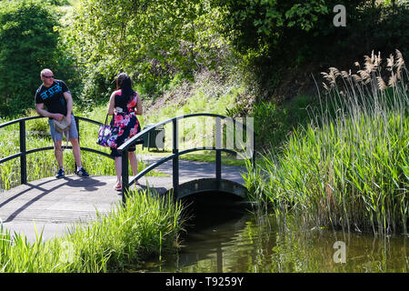 Fort giardini, Gravesend, Kent, Regno Unito. Un giovane su una passerella su un laghetto nei giardini di scattare foto di ogni altro. Foto Stock