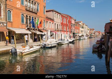 Barche ormeggiate sul canal con colorati edifici residenziali, l'isola di Murano, laguna di Venezia, Veneto, Italia Foto Stock