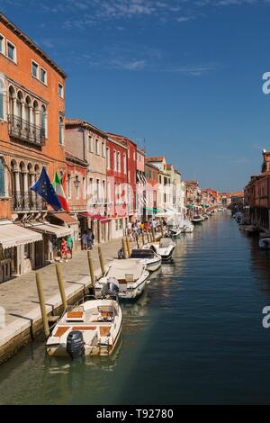 Barche ormeggiate sul canal con colorati edifici residenziali, l'isola di Murano, laguna di Venezia, Veneto, Italia Foto Stock