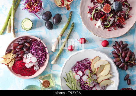 Piastre con verdure fresche insalate sulla tabella dei colori Foto Stock