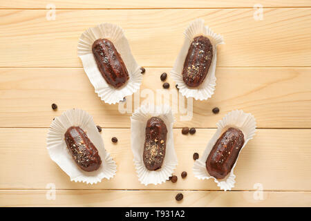 Gustosa eclairs sul tavolo di legno Foto Stock