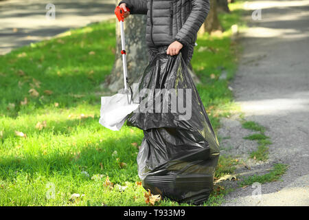 Donna nel cestino di raccolta in posizione di parcheggio Foto Stock