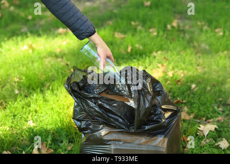 Donna nel cestino di raccolta in posizione di parcheggio Foto Stock