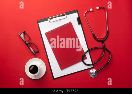 Uno stetoscopio in medici scrivania con tavoletta e la tazza di caffè. Vista da sopra con posto per il vostro testo. Foto Stock