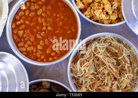 Bahrain colazione a base di fagioli, balaleet, vermicelli, uova strapazzate, pomodori, frittura di fegato, in ciotole di metallo Foto Stock