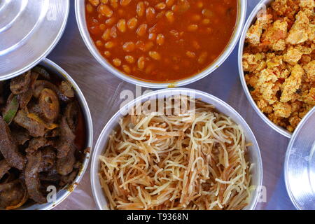 Bahrain colazione a base di fagioli, balaleet, vermicelli, uova strapazzate, pomodori, frittura di fegato, in ciotole di metallo Foto Stock