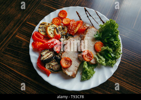 Carne di maiale alla griglia e zucca su una padella per grigliare. Vista verticale da sopra Foto Stock