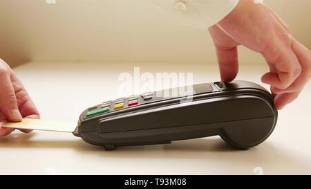 Lo sfioramento a mano carta di credito nel negozio. Mani femminili con carta di credito e bonifico terminale. Immagine a colori di un POS e carte di credito Foto Stock