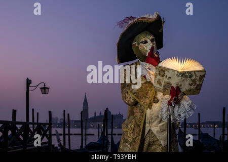 Ritratto di un masculin persona mascherata in un bellissimo costume di creative, ponendo al Grand Canal, il Canal Grande, celebra il Carnevale veneziano, la isla Foto Stock