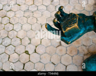 Dettaglio della statua di bronzo, una mano che regge un lastricato in pietra, Lisbona Portogallo Foto Stock