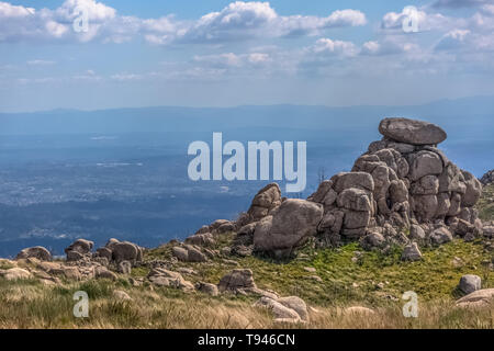 Vista dalla cima del Caramulo montagne oltre i Estrela montagne, rocce granitiche e macchia mediterranea in Portogallo Foto Stock