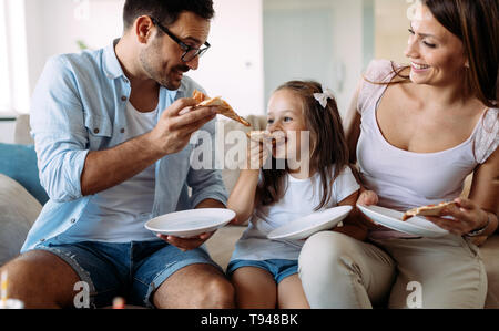 Ritratto di famiglia felice condivisione la pizza a casa Foto Stock