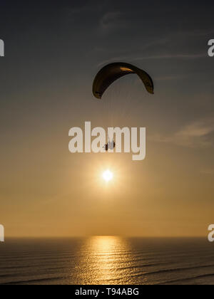 Parapendio sulle scogliere della città di Lima in Perù durante il tramonto Foto Stock