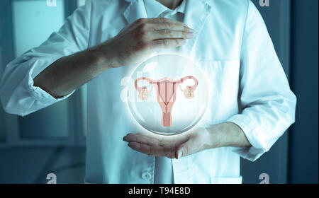 Reproductologist tenendo un modello olografico di utero e ovaie. Il trattamento dell'infertilità Concept Foto Stock