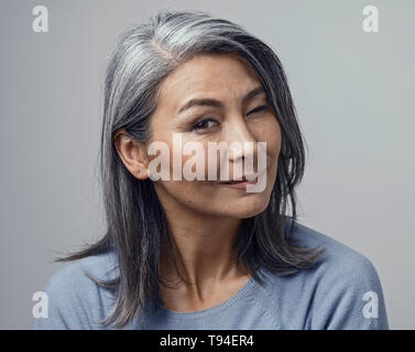 Asia affascinante donna matura sorrisi a fotocamera Foto Stock