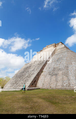 La piramide Maya - turista alla ricerca fino a piramide del mago, viaggi e turismo; presso le rovine maya di al sito UNESCO di Uxmal, Messico America Latina Foto Stock