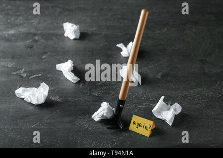Rastrello, carta sgualcita e scheda con nuovo testo su sfondo grigio. Concetto di apprendimento da errore Foto Stock