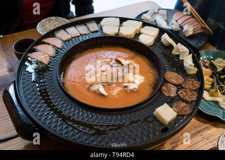 Hot Pot Restaurant a Chengdu Sichuan, in Cina. Il cibo viene cotto in un brodo a tavola Foto Stock