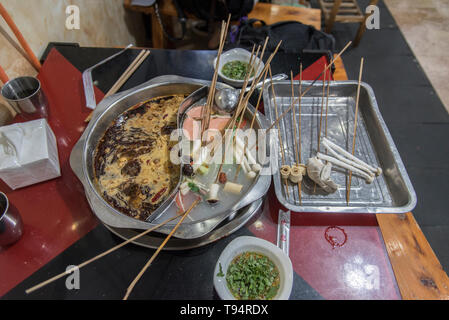 Hot Pot Restaurant a Chengdu Sichuan, in Cina. Il cibo viene cotto in un brodo a tavola Foto Stock