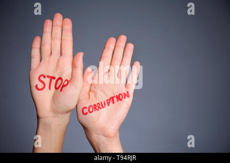 Palme femmina con testo scritto fermare la corruzione su sfondo grigio Foto Stock