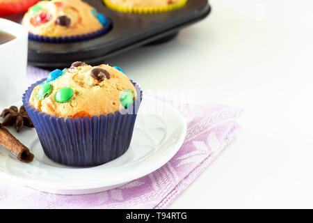 In casa limone piccante muffin con cioccolato colorato candy nel caso della carta. Sfondo bianco. Messa a fuoco selettiva. Foto Stock