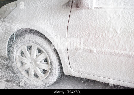 Autolavaggio, autolavaggio con schiuma attiva. Cura del veicolo. Donna  lavatrice auto con una spazzola Foto stock - Alamy