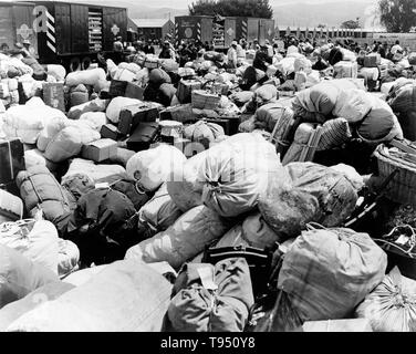 Dal titolo: 'bagaglio appartenenti a sfollati di ascendenza Giapponese presso un centro di raccolta in Salinas, California.' Il confino di Japanese-Americans durante la seconda guerra mondiale è stato il trasferimento forzato e la detenzione nei campi di 110,000-120,000 persone di ascendenza giapponese (62% degli internati erano cittadini statunitensi) ordinato dal presidente Roosevelt poco dopo il Giappone di attacco a Pearl Harbor. Japanese-Americans sono stati incarcerati basato sulla popolazione locale di concentrazioni e politica regionale. Foto Stock