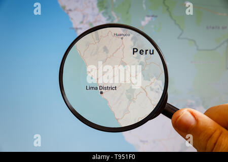 Lima, Perù. Mappa politico. La città sullo schermo del monitor attraverso una lente di ingrandimento in mano. Foto Stock