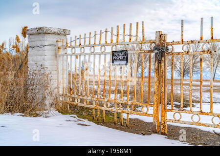 La proprietà privata senza sconfinamenti di segno su un metallo arrugginito cancello visto in inverno Foto Stock