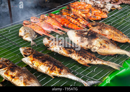 Assortimento di grigliate di pesce e di gamberetti lay sul verde del contatore del marketplace. Il principale mercato del pesce di Kota Kinabalu, Malaysia Foto Stock