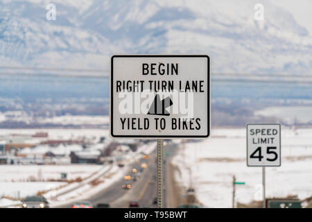 Segnaletica stradale con una sfocata paesaggi innevati e montagna in background Foto Stock