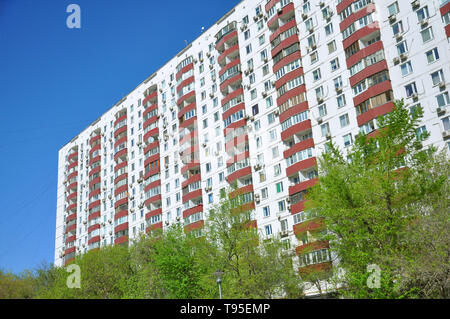 Facciata di un edificio a più piani. Su uno sfondo di colore blu eb e boccole Foto Stock