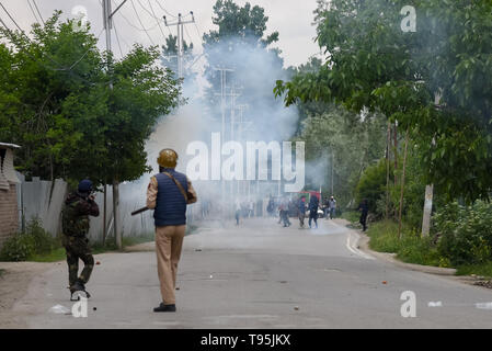 Srinagar Kashmir. 16 maggio 2019. Un poliziotto indiano visto sparando gas lacrimogeni barattolo di fumo verso i manifestanti durante gli scontri di Pulwama, a sud di Srinagar.Tre militanti, un esercito uomo e un civile sono stati uccisi in una feroce gunfight che scoppiò in Dalipora area di Pulwama città nel sud del Kashmir il giovedì mattina. Credito: Idrees Abbas SOPA/images/ZUMA filo/Alamy Live News Foto Stock